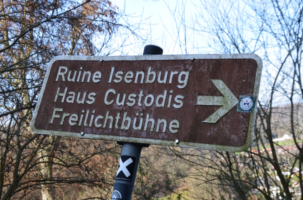 Verwitterter Wegweiser zur Ruine Isenburg Hattingen, Haus Custodis und stillgelegte Freilichbühne.